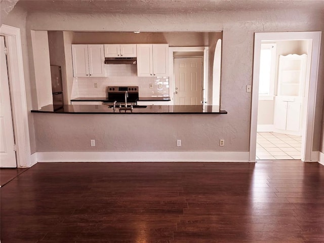 kitchen with appliances with stainless steel finishes, dark hardwood / wood-style flooring, backsplash, sink, and white cabinets