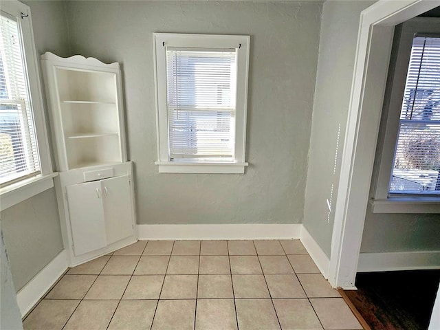 tiled spare room featuring plenty of natural light