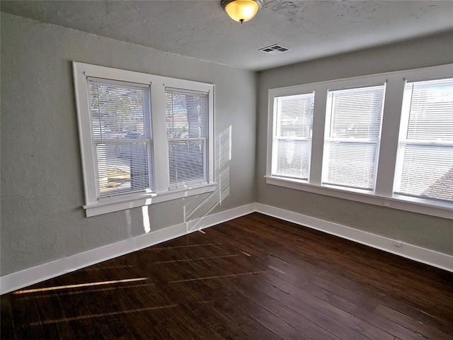 empty room with dark hardwood / wood-style flooring