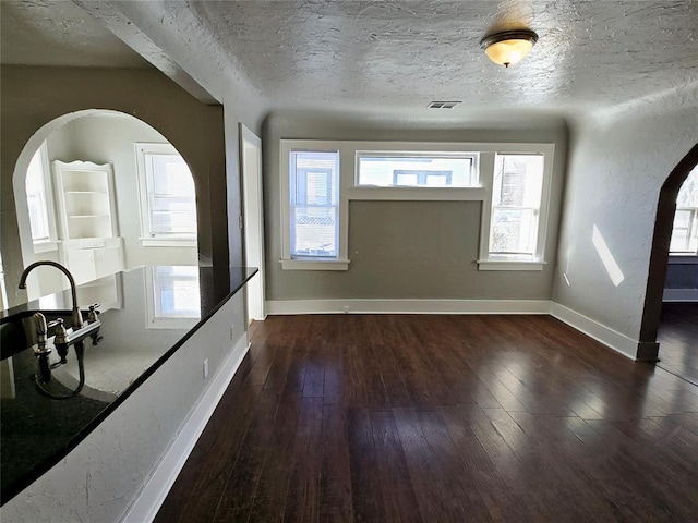 entrance foyer with dark wood-type flooring and a textured ceiling