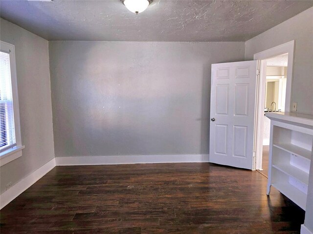 empty room with dark hardwood / wood-style flooring