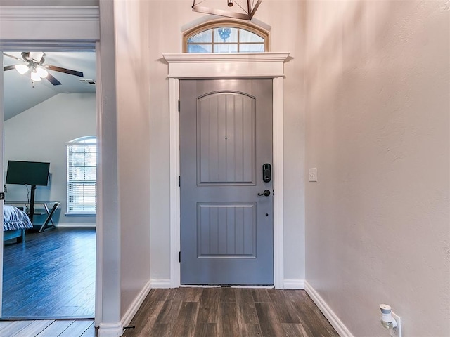 foyer entrance with ceiling fan, lofted ceiling, and dark wood-type flooring