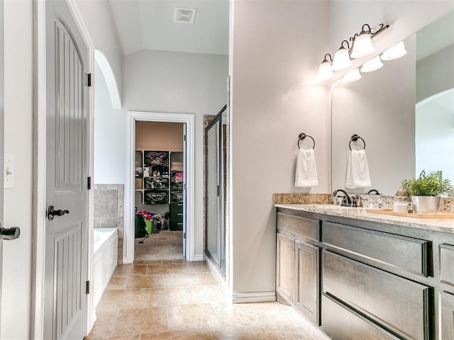 bathroom with separate shower and tub, vanity, and vaulted ceiling