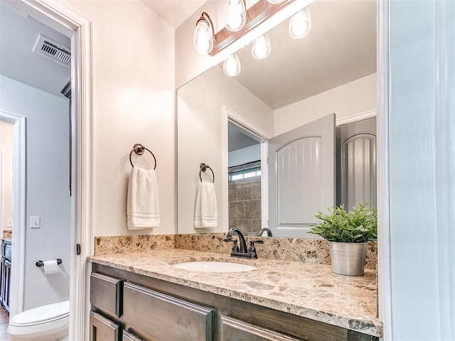 bathroom featuring vanity and toilet