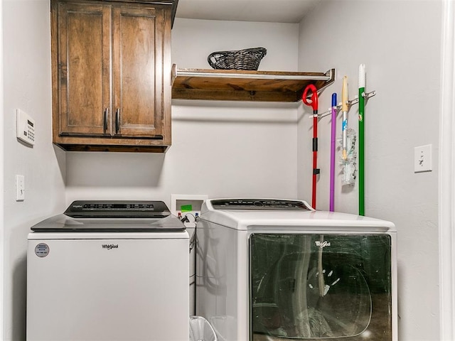 laundry room with washer and dryer and cabinets