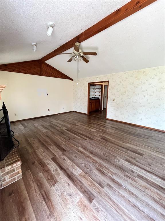 15268 Pheasant Run, Choctaw, OK 73020 - unfurnished living room with ceiling fan, wood finished floors, baseboards, wallpapered walls, and a textured ceiling