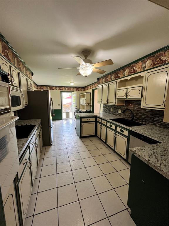 15268 Pheasant Run, Choctaw, OK 73020 - kitchen featuring a sink, a peninsula, ceiling fan, light tile patterned floors, and white microwave