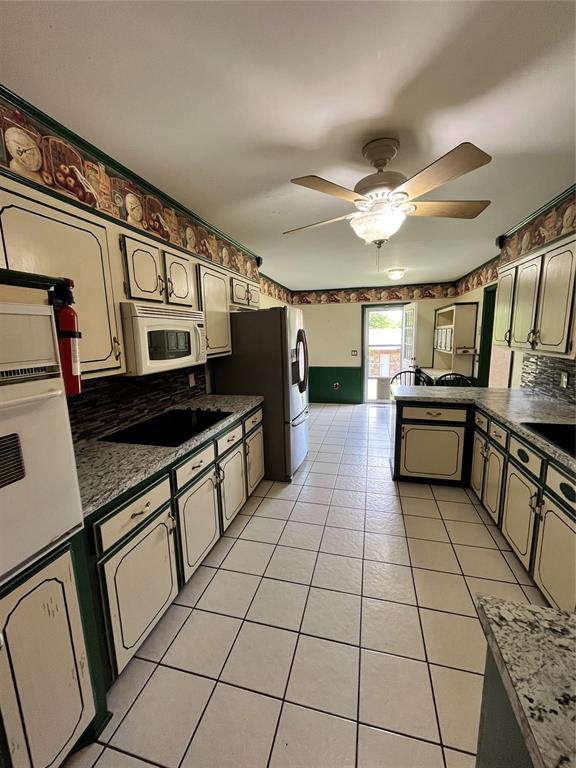 15268 Pheasant Run, Choctaw, OK 73020 - kitchen with white appliances, dark countertops, a peninsula, and light tile patterned floors