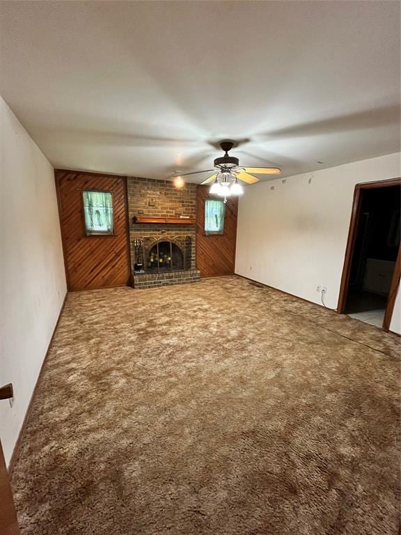 15268 Pheasant Run, Choctaw, OK 73020 - unfurnished living room featuring wooden walls, a ceiling fan, carpet, a fireplace, and healthy amount of natural light