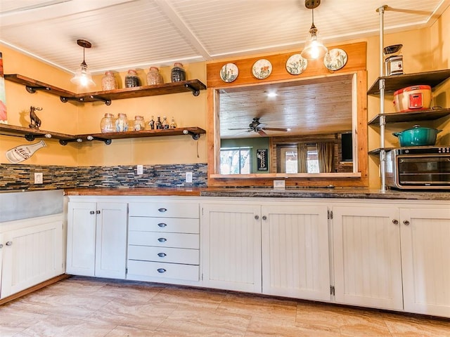 kitchen featuring backsplash, decorative light fixtures, white cabinetry, and ceiling fan