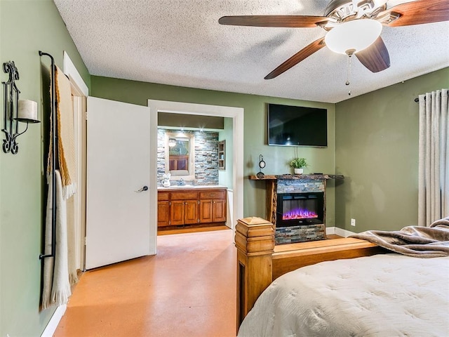 bedroom with a textured ceiling, ensuite bathroom, ceiling fan, and sink