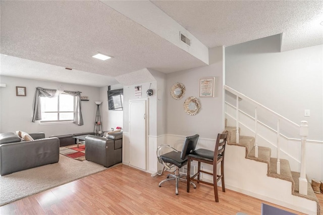 living room with a textured ceiling and hardwood / wood-style flooring