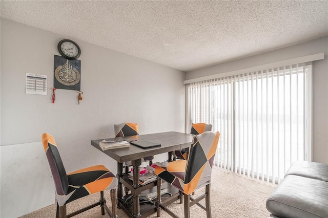 dining area with plenty of natural light, carpet floors, and a textured ceiling