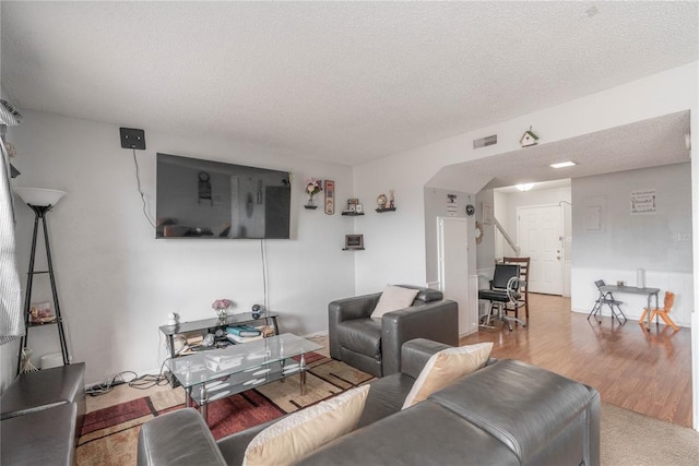 living room with hardwood / wood-style flooring and a textured ceiling