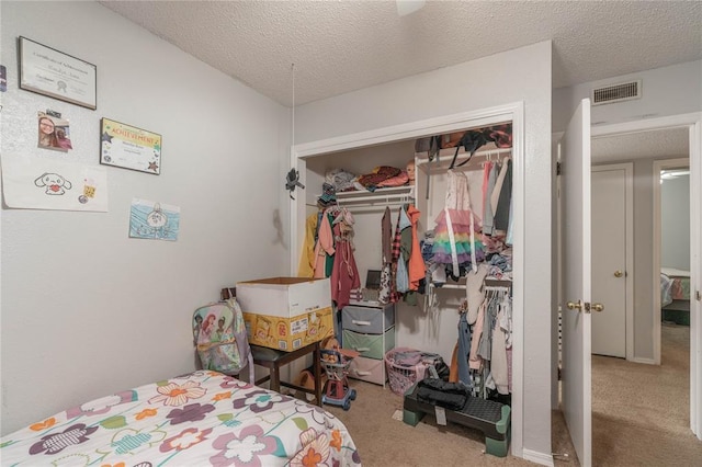 carpeted bedroom with a closet and a textured ceiling