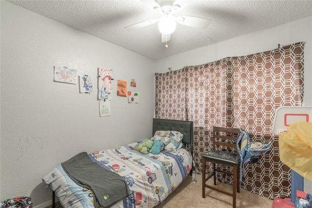 carpeted bedroom featuring ceiling fan and a textured ceiling