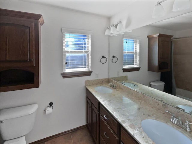 full bathroom with tile patterned flooring, vanity, a healthy amount of sunlight, and toilet