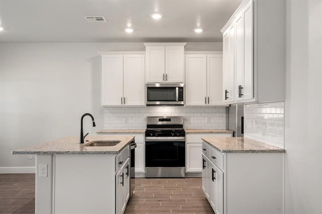 kitchen featuring white cabinets, sink, stainless steel appliances, and light hardwood / wood-style flooring