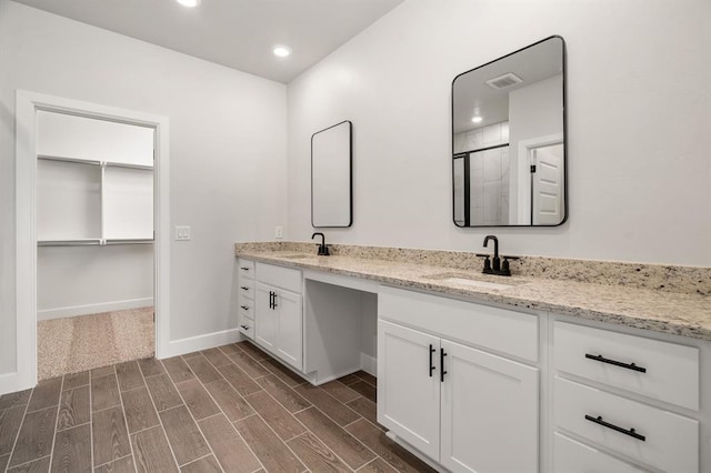 bathroom featuring hardwood / wood-style flooring, vanity, and walk in shower