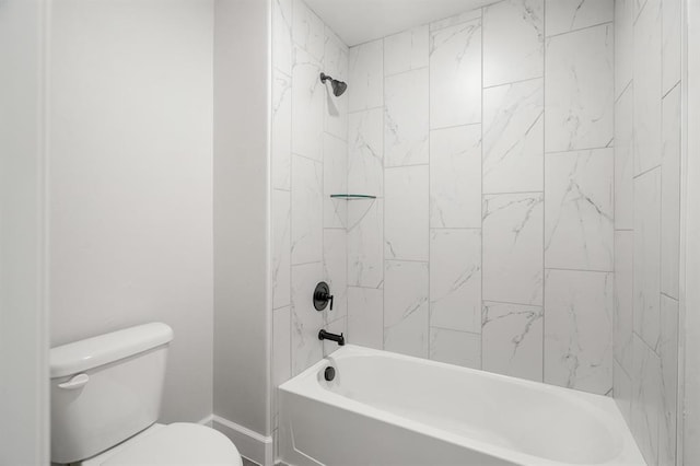 bathroom featuring tiled shower / bath combo and toilet