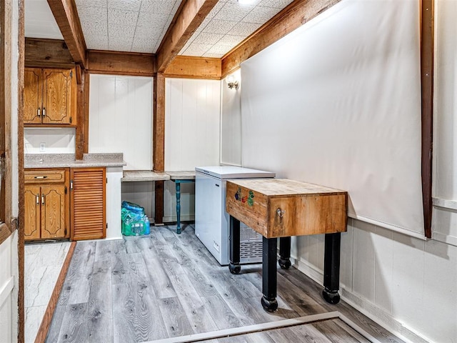 misc room with beamed ceiling, light wood-type flooring, and a paneled ceiling