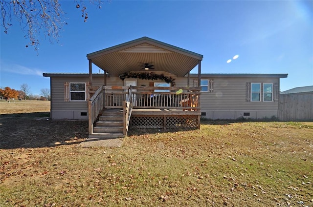 rear view of house with a lawn, ceiling fan, and a deck