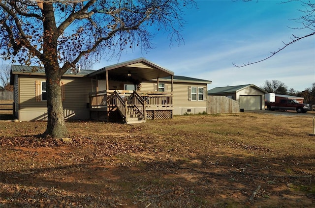 rear view of house featuring a porch, a garage, and an outdoor structure