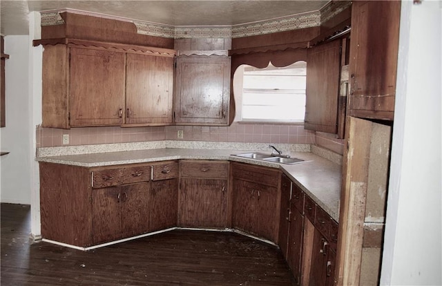 kitchen with tasteful backsplash, sink, and dark wood-type flooring