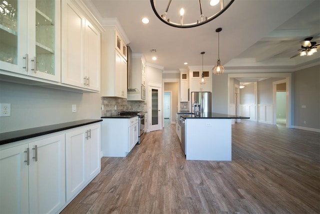 kitchen with white cabinets, pendant lighting, a kitchen island with sink, and appliances with stainless steel finishes