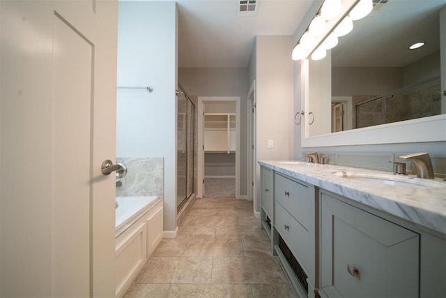 bathroom with vanity and shower with separate bathtub