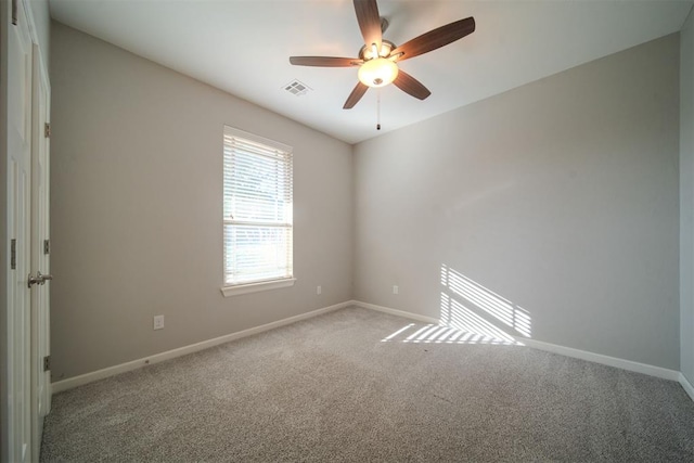 carpeted spare room featuring ceiling fan