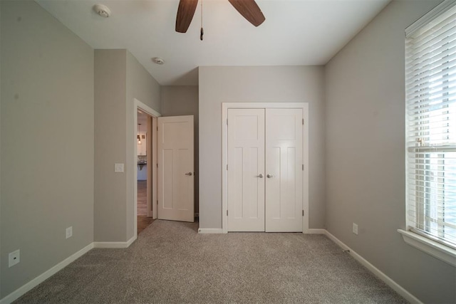 unfurnished bedroom featuring carpet flooring, ceiling fan, and a closet