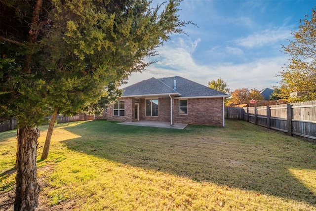 rear view of property featuring a lawn and a patio