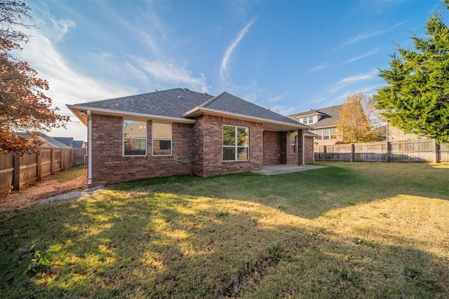 rear view of property featuring a lawn and a patio area