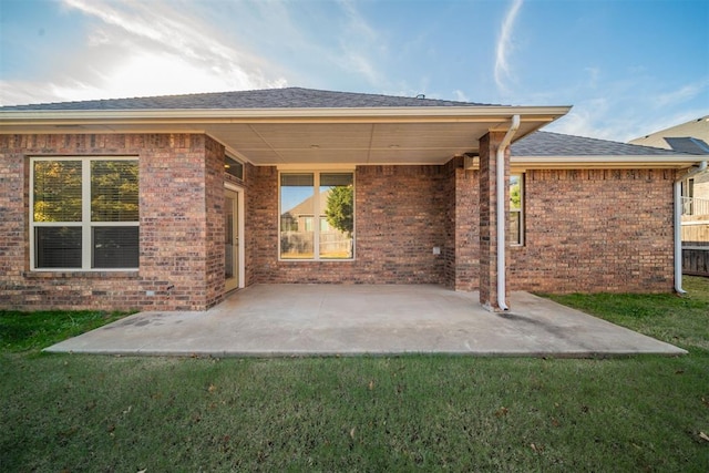 rear view of house with a yard and a patio