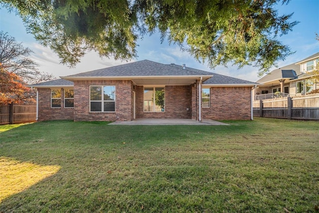 rear view of house featuring a yard and a patio