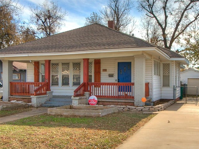 bungalow-style house featuring a porch and an outdoor structure