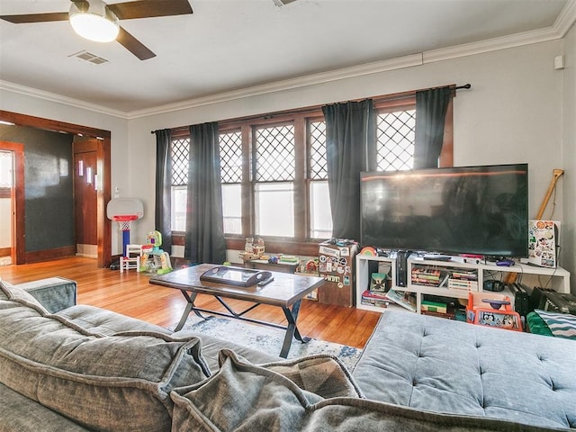 living room featuring light hardwood / wood-style floors, ceiling fan, and crown molding