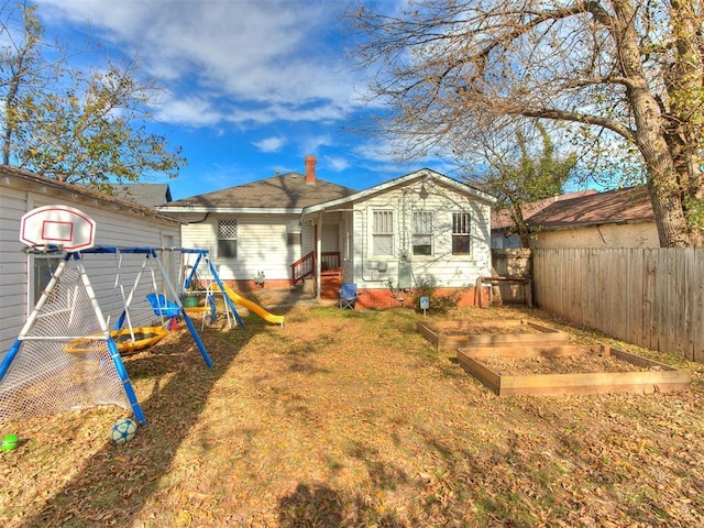 rear view of house featuring a playground