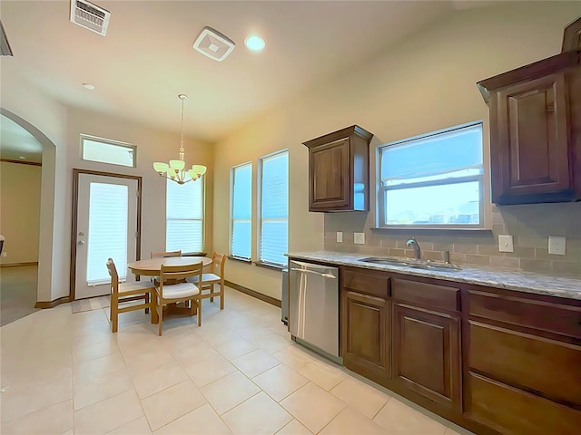 kitchen with sink, tasteful backsplash, stainless steel dishwasher, a notable chandelier, and decorative light fixtures