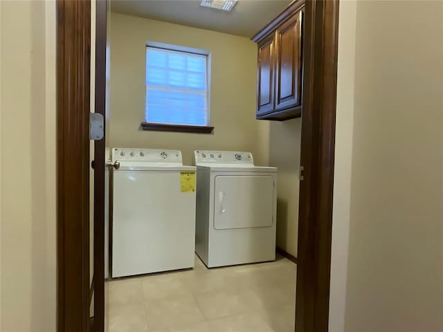 laundry area featuring washer and clothes dryer and cabinets