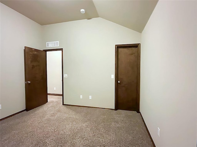 unfurnished bedroom with light colored carpet and vaulted ceiling