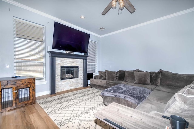 living room with a fireplace, hardwood / wood-style floors, ceiling fan, and crown molding