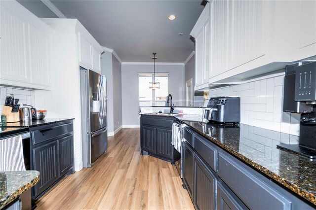 kitchen featuring crown molding, pendant lighting, white cabinets, and stainless steel appliances