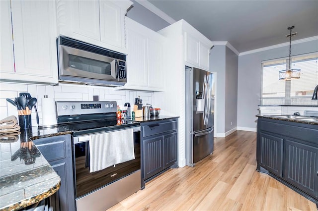 kitchen featuring white cabinetry, sink, stainless steel appliances, tasteful backsplash, and light hardwood / wood-style flooring