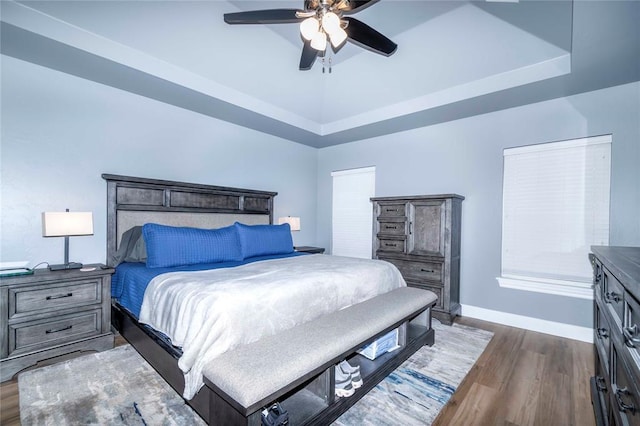 bedroom featuring a tray ceiling, ceiling fan, and dark hardwood / wood-style floors