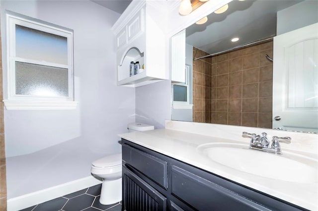 bathroom featuring tiled shower, tile patterned floors, vanity, and toilet