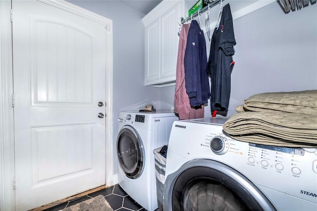 laundry area with tile patterned floors, washing machine and dryer, and cabinets