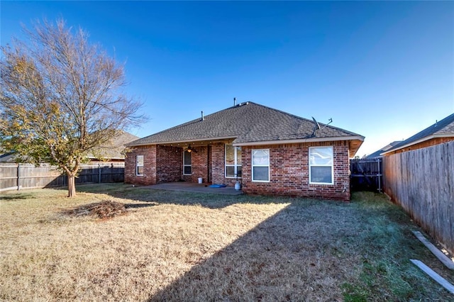 rear view of house featuring a yard and a patio