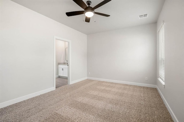 carpeted spare room featuring ceiling fan